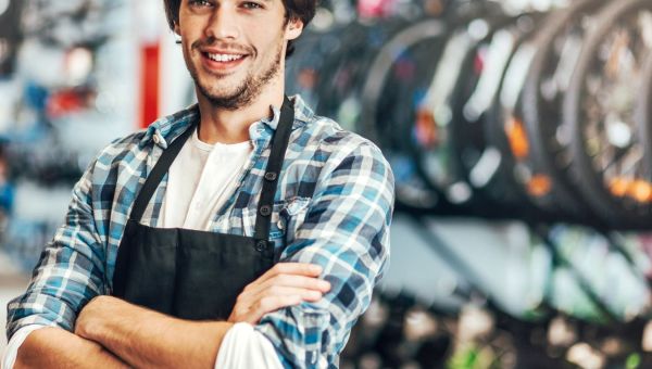Young man with invisible disability standing behind counter in bicycle store